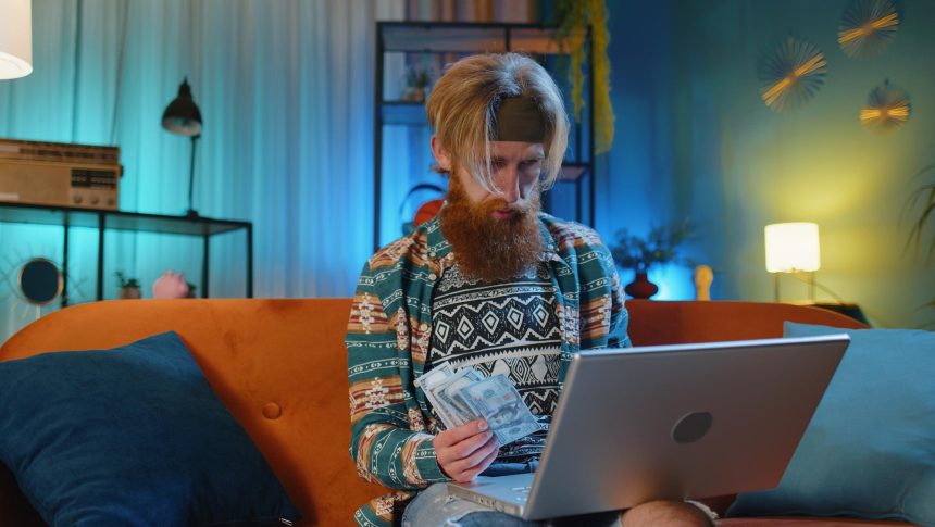 Kobieta używająca laptopa siedząc w domu na kanapie