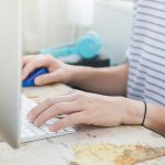 Środkowa sekcja osoby używającej laptopa na stole