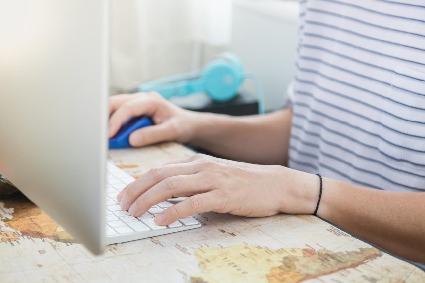 Środkowa sekcja osoby używającej laptopa na stole