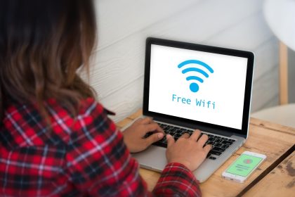 Z tyłu widok kobiety używającej laptopa na stole