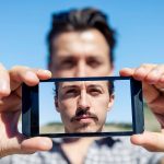 Młody, uroczy dorosły robi selfie ze smartfonem.