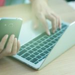 Środkowa sekcja mężczyzny używającego laptopa na stole