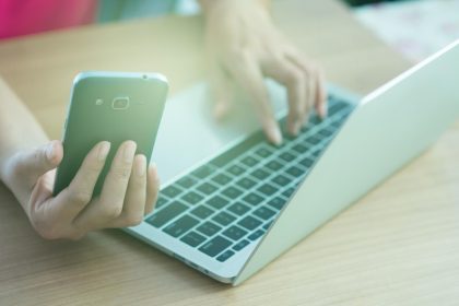 Środkowa sekcja mężczyzny używającego laptopa na stole