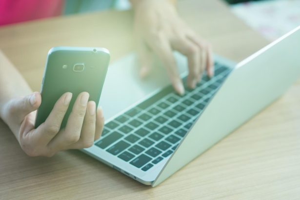 Środkowa sekcja mężczyzny używającego laptopa na stole