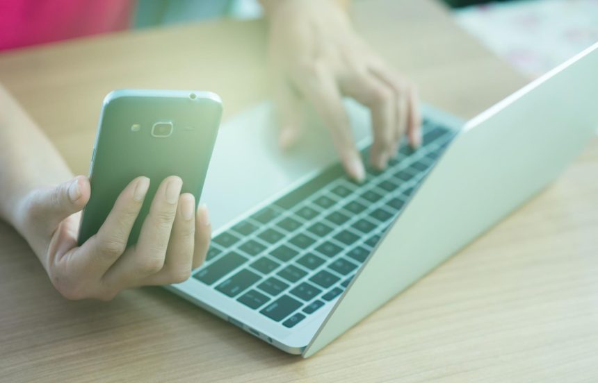 Środkowa sekcja mężczyzny używającego laptopa na stole