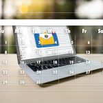 Cyfrowy kompozytowy obraz znaku informacyjnego na laptopie i kalendarzu na biurku przy ścianie