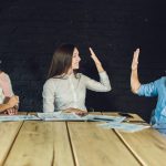 Młody zespół współpracowników oglądający storyboard do kręcenia wideo w nowoczesnym biurze coworkingowym