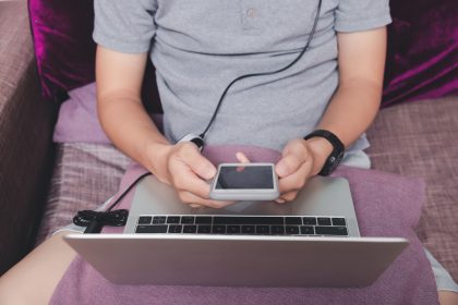 Mężczyzna trzymający smartfon w jednym rogu domowego biura.