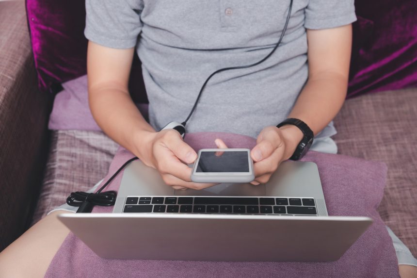 Mężczyzna trzymający smartfon w jednym rogu domowego biura.