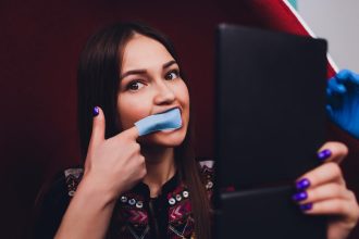 Portret młodej kobiety odwiedzającej gabinet dentystyczny w celu wybielenia zębów za pomocą fotopolimeru