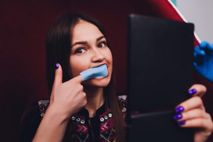 Portret młodej kobiety odwiedzającej gabinet dentystyczny w celu wybielenia zębów za pomocą fotopolimeru