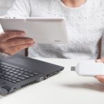 Dziewczyna trzymając się za ręce pendrive i tablet