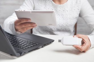 Dziewczyna trzymając się za ręce pendrive i tablet