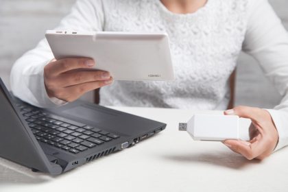 Dziewczyna trzymając się za ręce pendrive i tablet