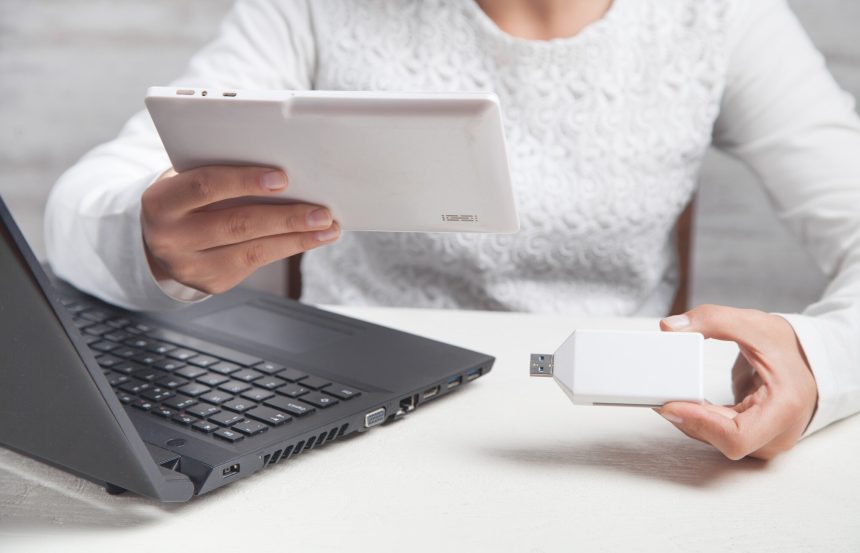 Dziewczyna trzymając się za ręce pendrive i tablet