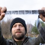 Mężczyzna z zainteresowaniem patrzy na starożytny film fotograficzny Koncepcja genealogii Pamięć o przodkach więzi rodzinne wspomnienia z dzieciństwa Historia i przeszłość Stare negatywy fotograficzne