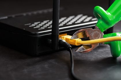 Przerwanie i przecięcie zielonych kawałków połączenia sieciowego żółtego przewodu połączenia internetowego.