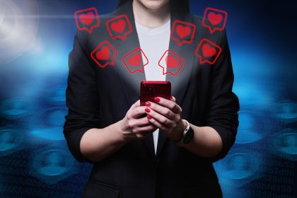 Zbliżenie rąk kobiety używającej smartfona z ikonami takimi jak serca