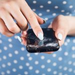 Młoda kobieta naciska na zepsuty ekran telefonu