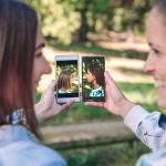 Szczęśliwe kobiety pokazujące smartfony z widokiem z boku na zdjęcia portretowe zrobione nad lasem