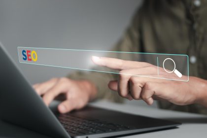 Koncepcja optymalizacji wyszukiwarek SEO Przedsiębiorca używający laptopa i dotykający ręką paska wyszukiwarki do wyszukiwania informacji o ruchu na stronach internetowych i rankingach stron internetowych