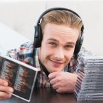 Człowiek ze słuchawkami słuchającymi płyt CD