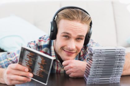 Człowiek ze słuchawkami słuchającymi płyt CD