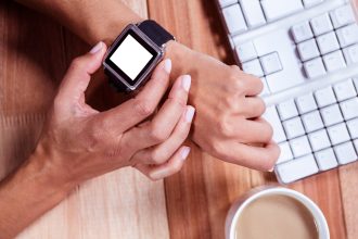 Kobiece ręce z zegarem smartwatch i kawą