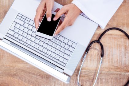Doktorski używa smartphone na drewnianym biurku