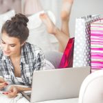 Młoda atrakcyjna kobieta robi zakupy online w domu