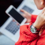 Zamknij się zdjęcie. Dziewczyna z laptopem i telefonem robi zakupy online. Detale.