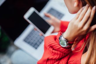 Zamknij się zdjęcie. Dziewczyna z laptopem i telefonem robi zakupy online. Detale.