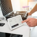 Technik pracuje z zestawem demonstracyjnym systemu inteligentnego domu
