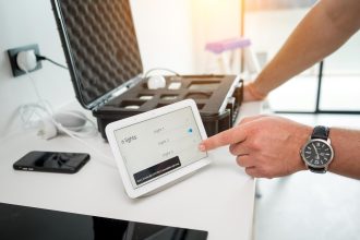 Technik pracuje z zestawem demonstracyjnym systemu inteligentnego domu