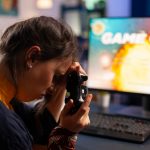 Profesjonalny gracz trzymający kontroler pod ręką po przegranej grze w kosmiczną strzelankę za pomocą bezprzewodowego joysticka. Konkurencyjny gracz korzystający z nowoczesnego sprzętu do mistrzostw online