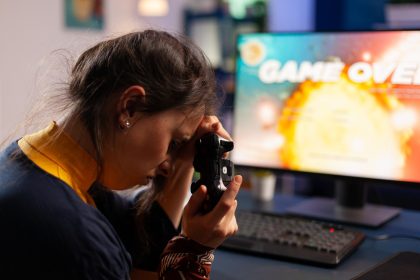 Profesjonalny gracz trzymający kontroler pod ręką po przegranej grze w kosmiczną strzelankę za pomocą bezprzewodowego joysticka. Konkurencyjny gracz korzystający z nowoczesnego sprzętu do mistrzostw online