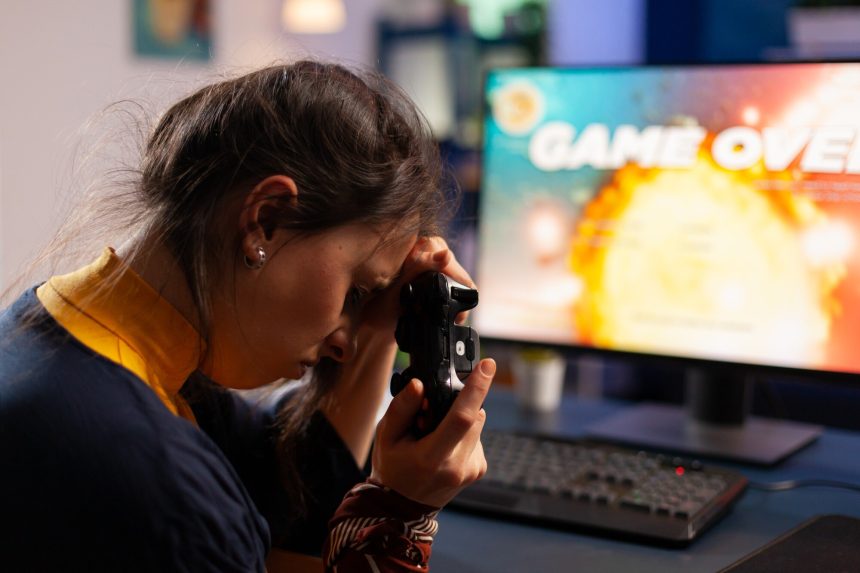 Profesjonalny gracz trzymający kontroler pod ręką po przegranej grze w kosmiczną strzelankę za pomocą bezprzewodowego joysticka. Konkurencyjny gracz korzystający z nowoczesnego sprzętu do mistrzostw online