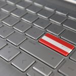 Klawiatura z flagą Austrii na przycisku enter reprezentuje język uczenia się cyberataku