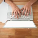 Obsługuje działanie na laptopie przy biurkiem w biurze