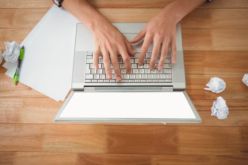 Obsługuje działanie na laptopie przy biurkiem w biurze