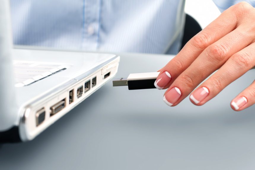 Ręka sekretarza wkłada pendrive.