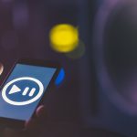 Tło muzyczne z telefonem i ikoną muzyki, koncepcja nowoczesnych technologii, słuchanie muzyki.