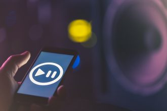 Tło muzyczne z telefonem i ikoną muzyki, koncepcja nowoczesnych technologii, słuchanie muzyki.
