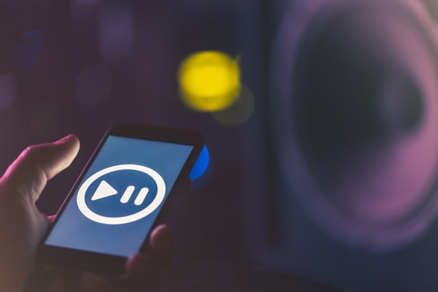 Tło muzyczne z telefonem i ikoną muzyki, koncepcja nowoczesnych technologii, słuchanie muzyki.