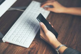 Kobieta ręka telefon z działającą klawiaturą na stole
