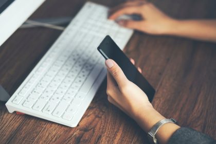 Kobieta ręka telefon z działającą klawiaturą na stole