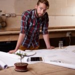Portret mężczyzny i architekta z planem podłogi dla inżynierii lub renowacji budowy i projektowania budynku Szkic planowy i rozwój nieruchomości z papierami architektonicznymi w warsztacie