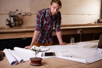 Portret mężczyzny i architekta z planem podłogi dla inżynierii lub renowacji budowy i projektowania budynku Szkic planowy i rozwój nieruchomości z papierami architektonicznymi w warsztacie