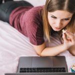 Kobieta z popcornem ogląda film na laptopie