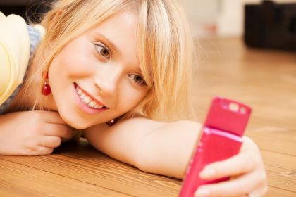 koncepcja technologii - nastolatka robi autoportret za pomocą smartfona